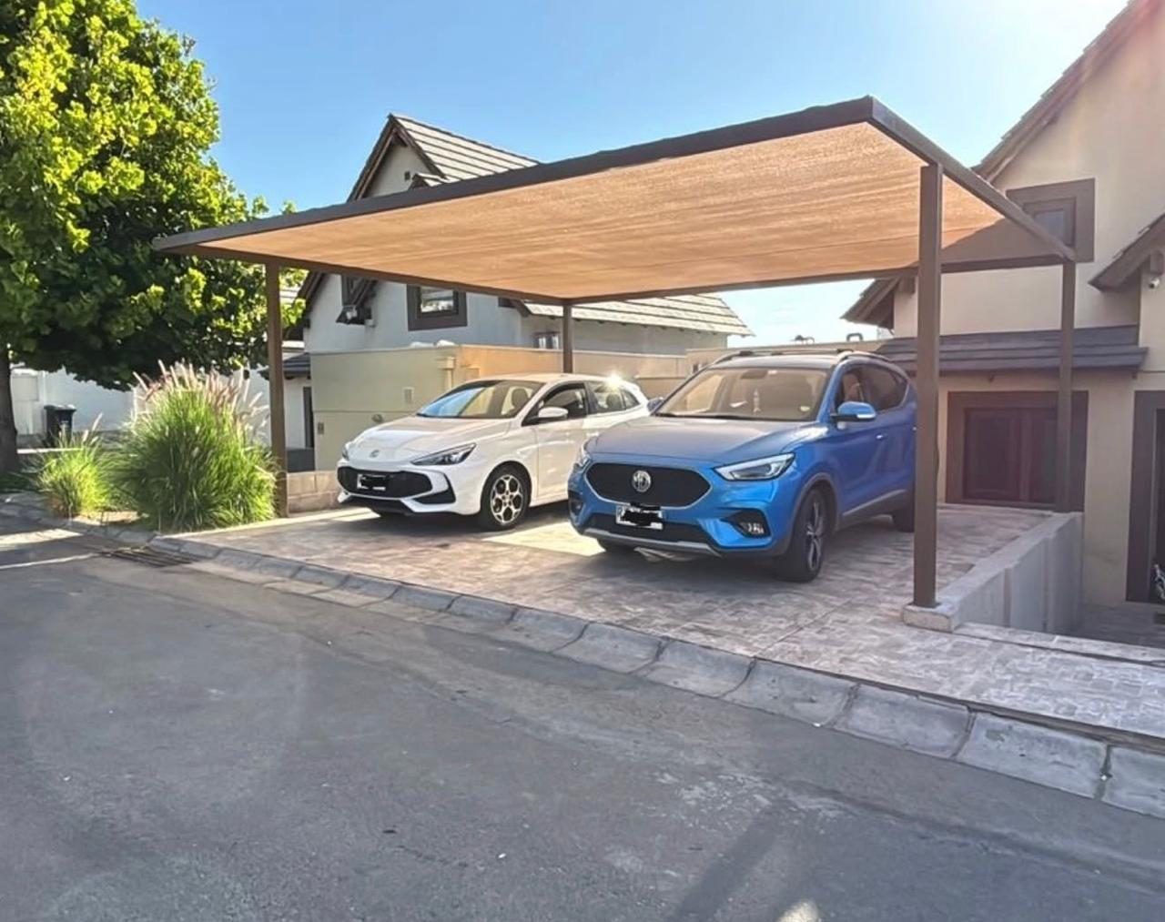 Estacionamiento techado para dos vehículos instalado en casa residencial.